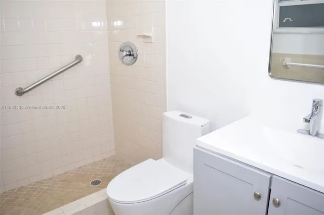 a white toilet sitting next to a bathroom sink and vanity