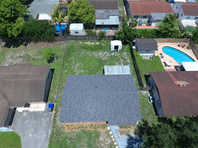 an aerial view of a house with a yard basket ball court and outdoor seating
