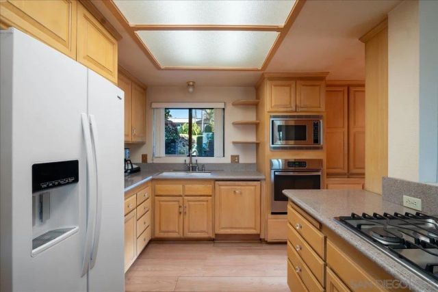 a kitchen with stainless steel appliances a sink stove and refrigerator
