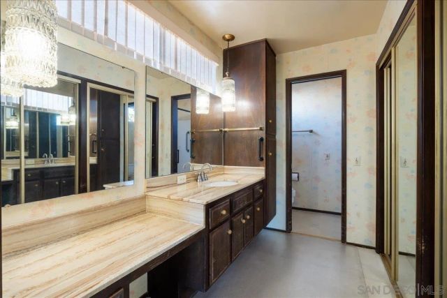 a spacious bathroom with a granite countertop double vanity and a shower