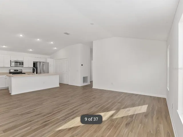 a view of kitchen with stainless steel appliances cabinets and wooden floor