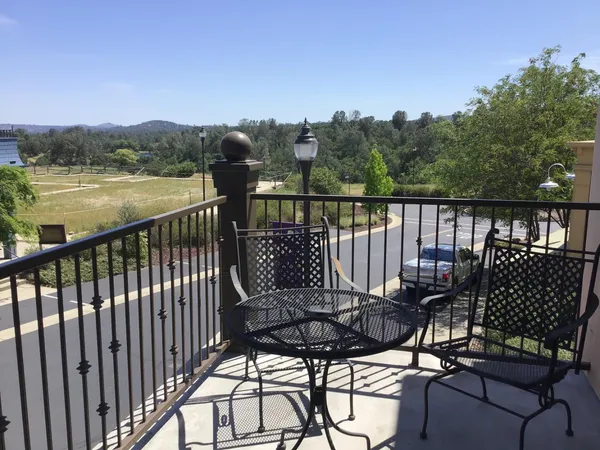 a view of a balcony with chairs and wooden floor