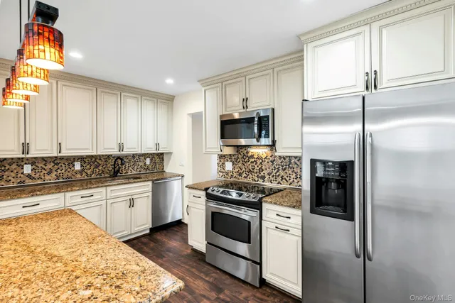 a kitchen with stainless steel appliances granite countertop a stove a refrigerator and a sink
