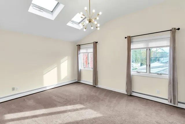 an empty room with chandelier and windows
