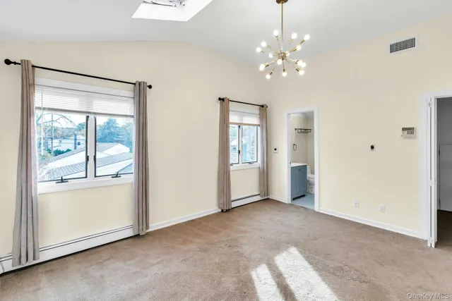 a view of a livingroom with a chandelier fan and windows