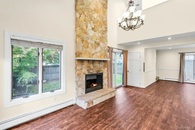 a living room with a fireplace furniture a flat screen tv and a window