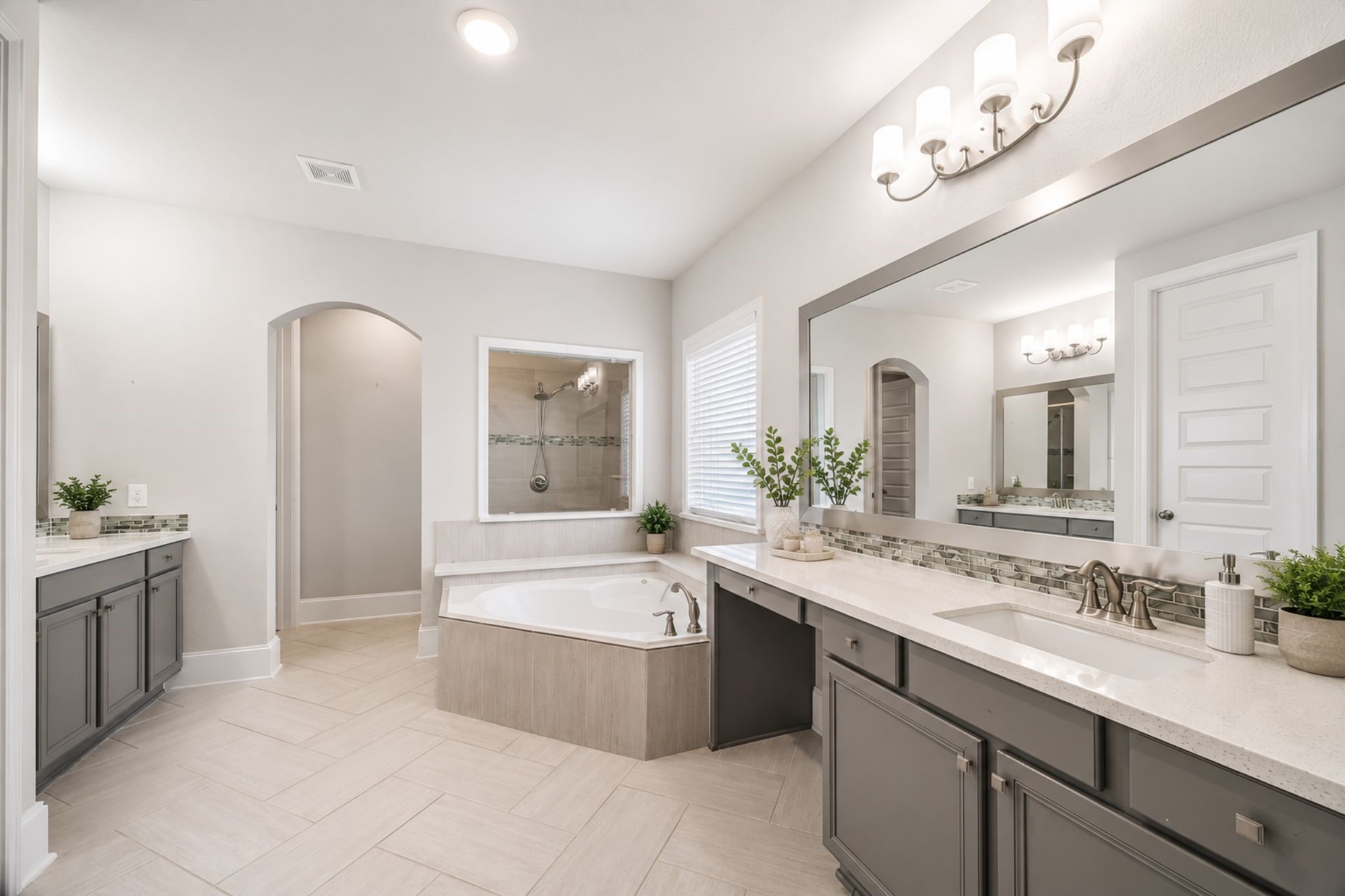 1907 Sapphire Pines Lane Rosenberg, TX 77469 - Photo 16 of 43 LUXURIOUS MASTER BATHROOM FEATURES DUAL VANITIES, A LARGE SOAKING TUB AND MASSIVE SHOWER. NOTE THE DETAIL OF THE DECORATIVE TILE WORK AT THE TOP OF THE QUARTZ COUNTERTOPS.