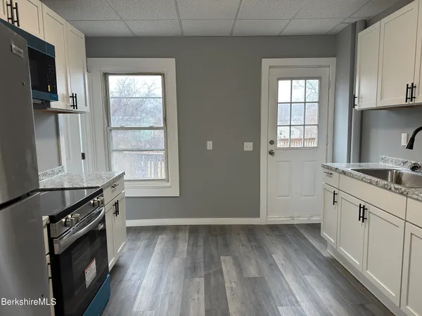 a kitchen with granite countertop a stove and a sink