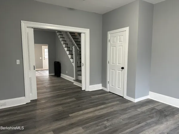 an empty room with wooden floor and closet