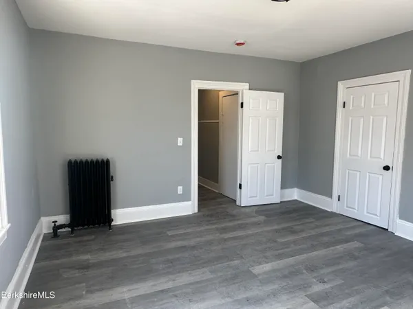 an empty room with wooden floor and closet