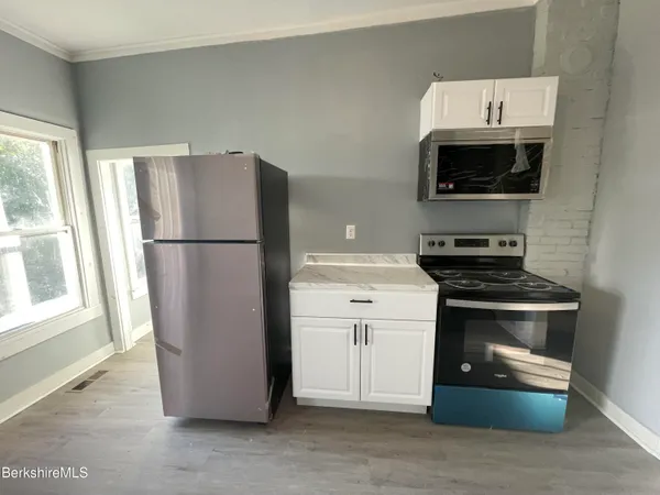 a kitchen with a refrigerator stove and microwave
