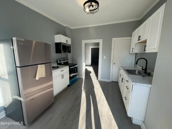 a kitchen with white cabinets and stainless steel appliances
