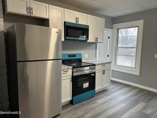 a kitchen with stainless steel appliances a refrigerator stove and microwave