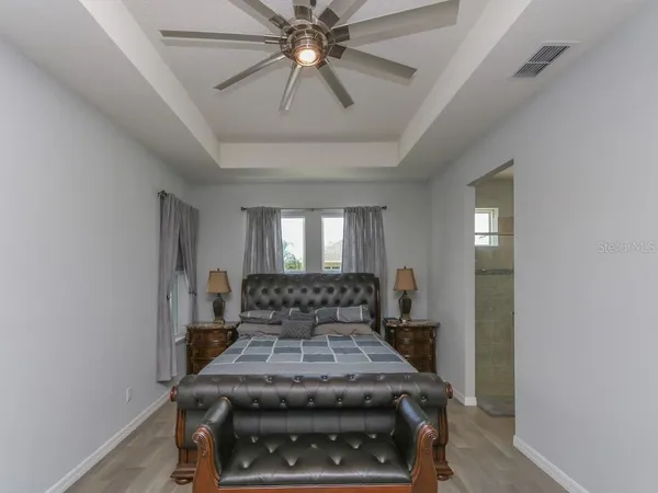 a bed sitting in a spacious bedroom next to a window