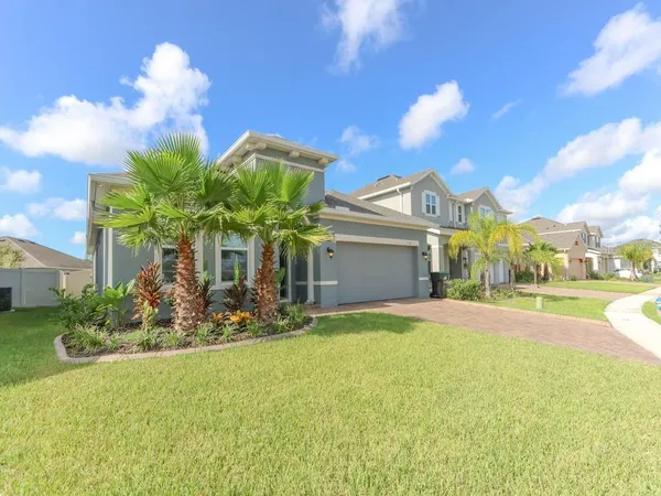 a view of a house with a yard and potted plants