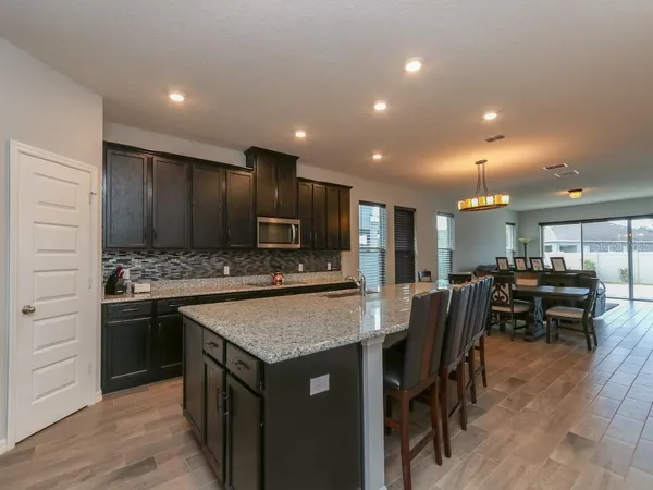 a open kitchen with stainless steel appliances granite countertop a sink and a refrigerator