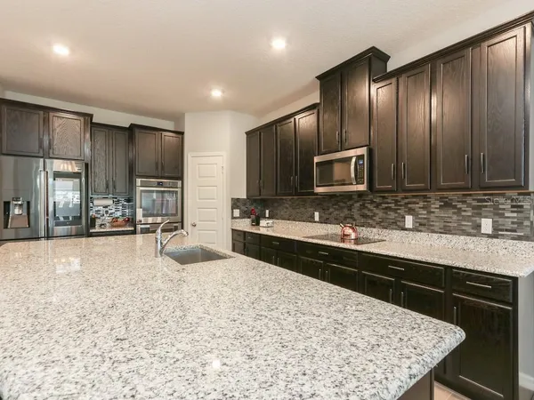 a kitchen with stainless steel appliances granite countertop a sink stove and refrigerator