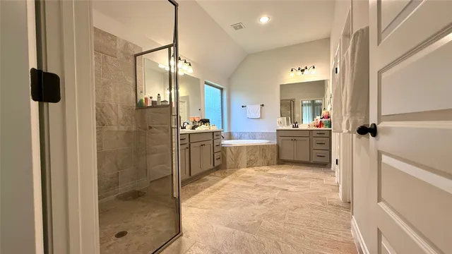 a bathroom with a tub sink shower and mirror
