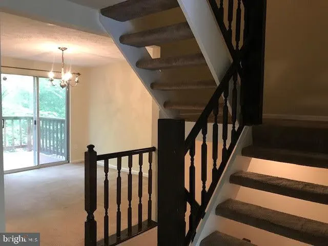 a view of staircase with lots of frames on wall and windows