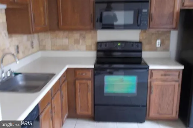 a kitchen with granite countertop wood cabinets and a stove top oven
