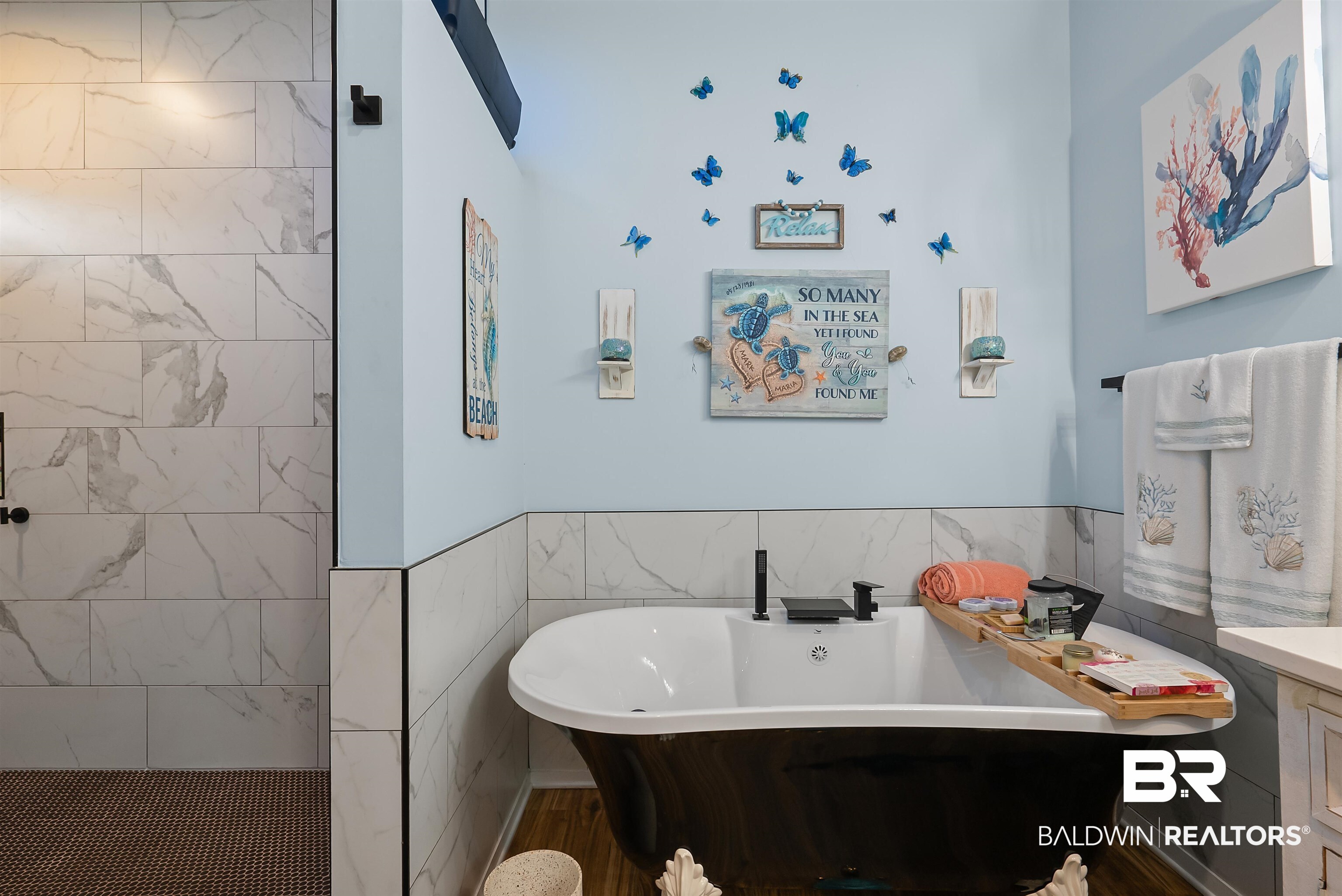 7266 Franklin Road Foley, AL 36535 - Photo 28 of 64 Freestanding soaking tub with matte black fixtures, featuring a surrounding tile wainscoting and wood-finish flooring
