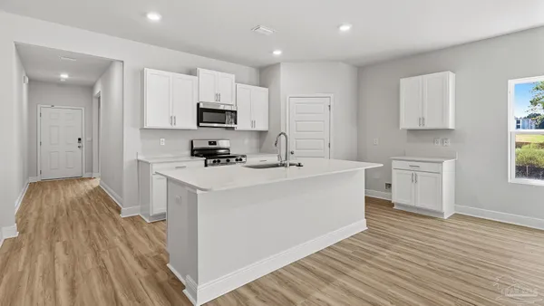a kitchen with white cabinets and appliances