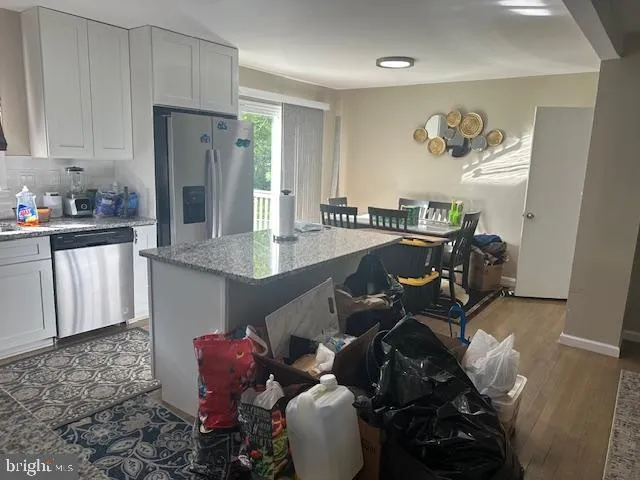 a living room with furniture and a refrigerator