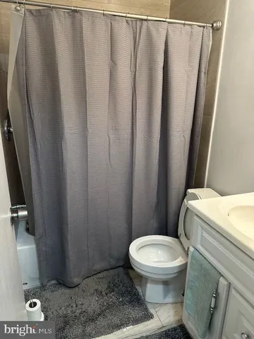 a white toilet sitting next to a shower curtain