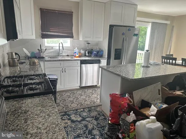 a kitchen with stainless steel appliances a sink stove and refrigerator