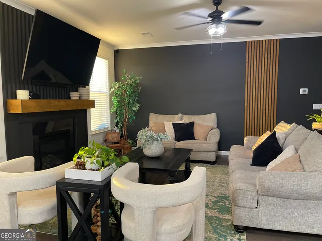 a living room with furniture a flat screen tv and a fireplace