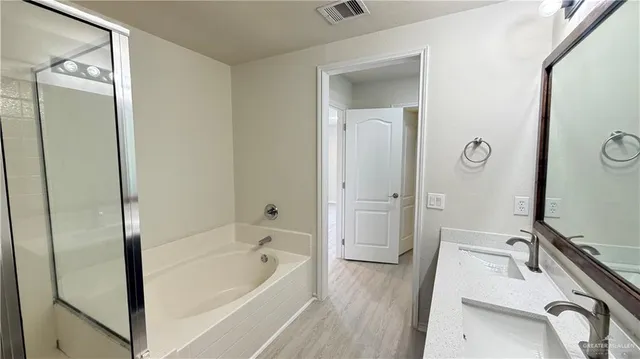 a bathroom with a tub sink and mirror