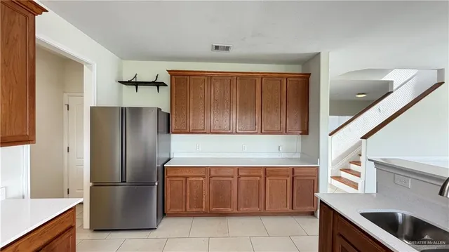 a kitchen with a refrigerator sink and cabinets