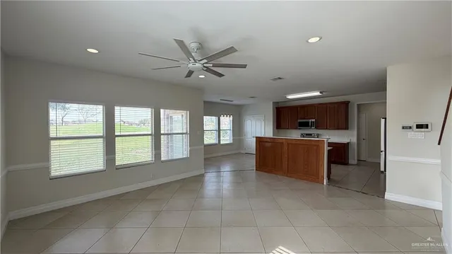 a large kitchen with kitchen island a sink a stove a washer dryer and a chandelier