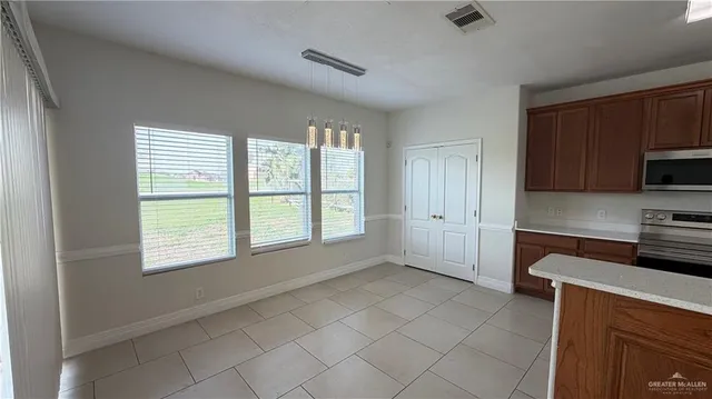 a kitchen with granite countertop a stove a sink and a microwave