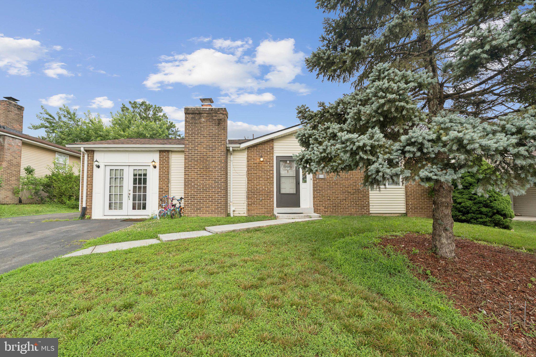 front view of a house with a yard and an trees