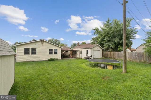 a view of a house with backyard and a tree