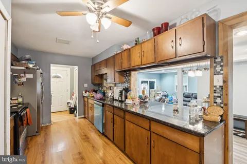 a kitchen with stainless steel appliances granite countertop a sink dishwasher and cabinets with wooden floor