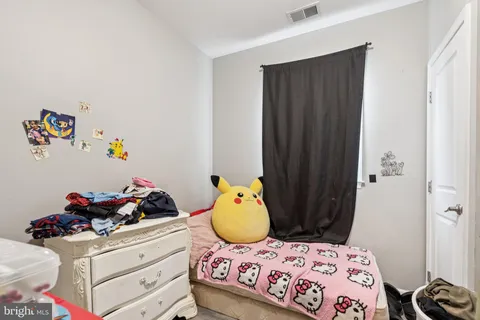 a bedroom with a bed and teddy bear on dresser