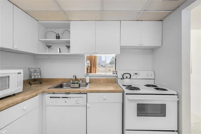 a kitchen with white cabinets and white appliances