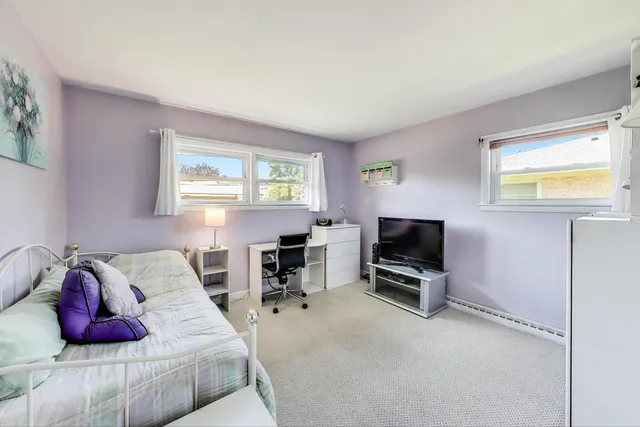 a bathroom with a toilet a sink a mirror and a window