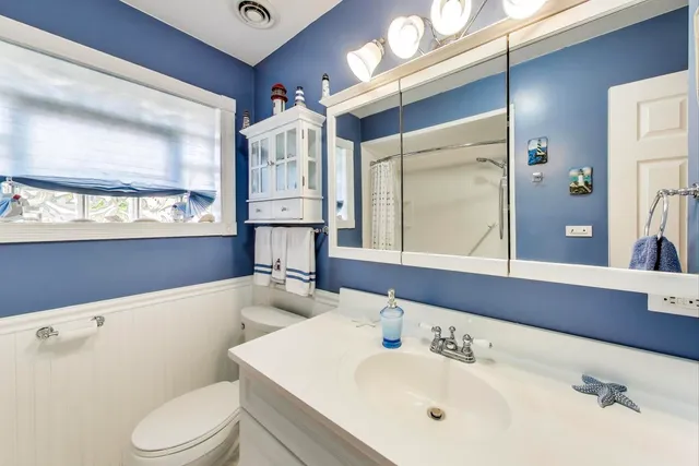 a bedroom with a bed a couch and a flat tv screen