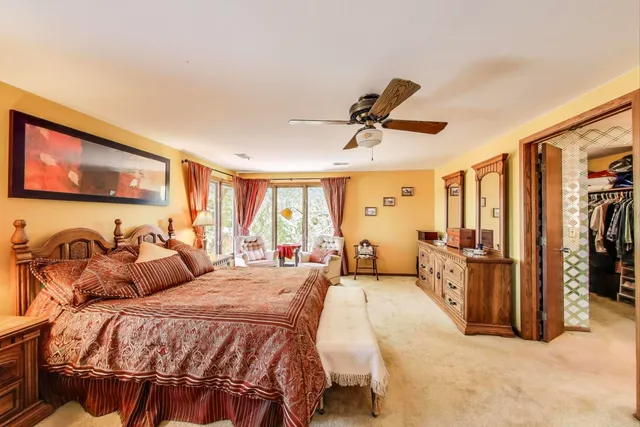 a bedroom with a bed couch and a large window