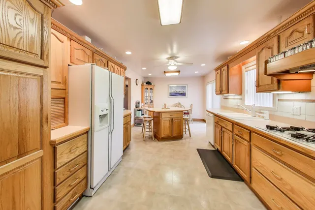 a kitchen with stainless steel appliances granite countertop a sink and cabinets with wooden floor