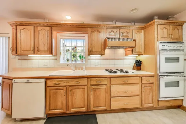 a kitchen with a table chairs sink and cabinets