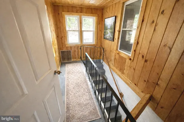 a view of a hallway with wooden floor and stairs