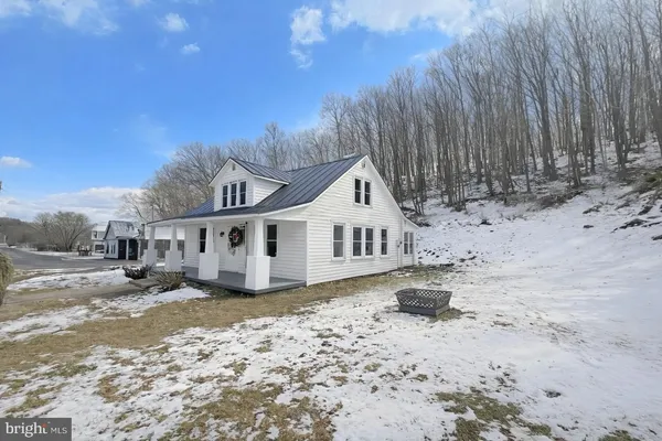 a view of a white house with a yard covered in snow