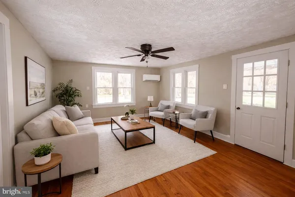 a living room with furniture ceiling fan and a window