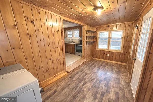 a view of a hallway with wooden floor and windows