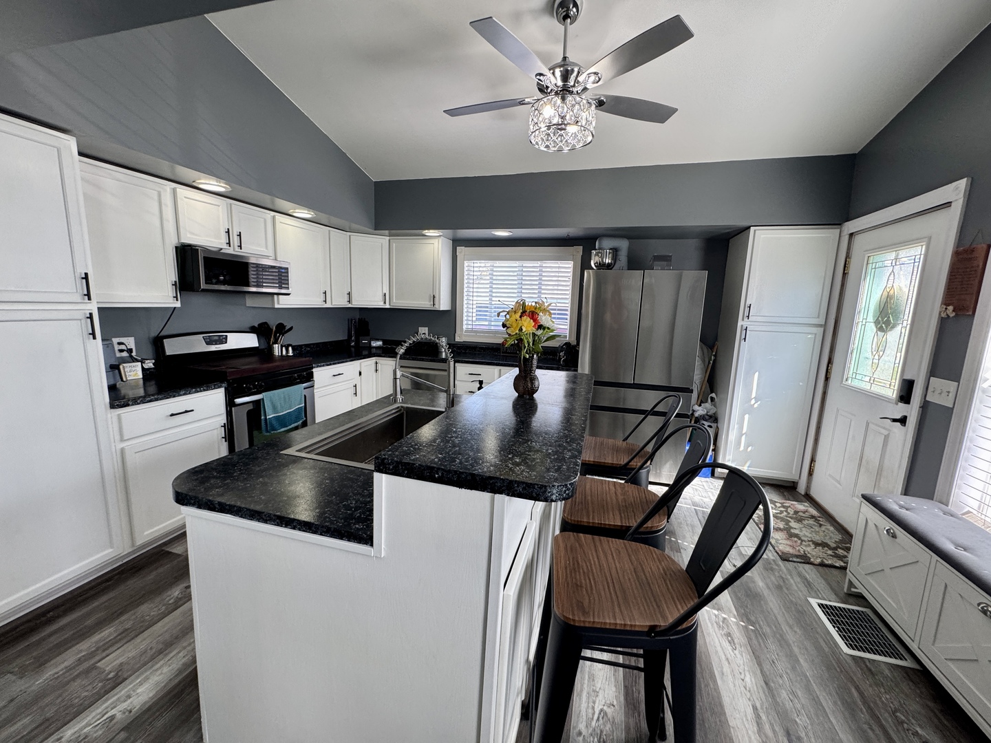 304 South Church Street Sheffield, IL 61361 - Photo 7 of 23 a kitchen with stainless steel appliances granite countertop a stove a refrigerator a sink a dining table and chairs with wooden floor