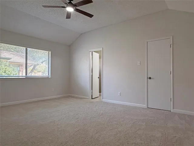 an empty room with windows and fan